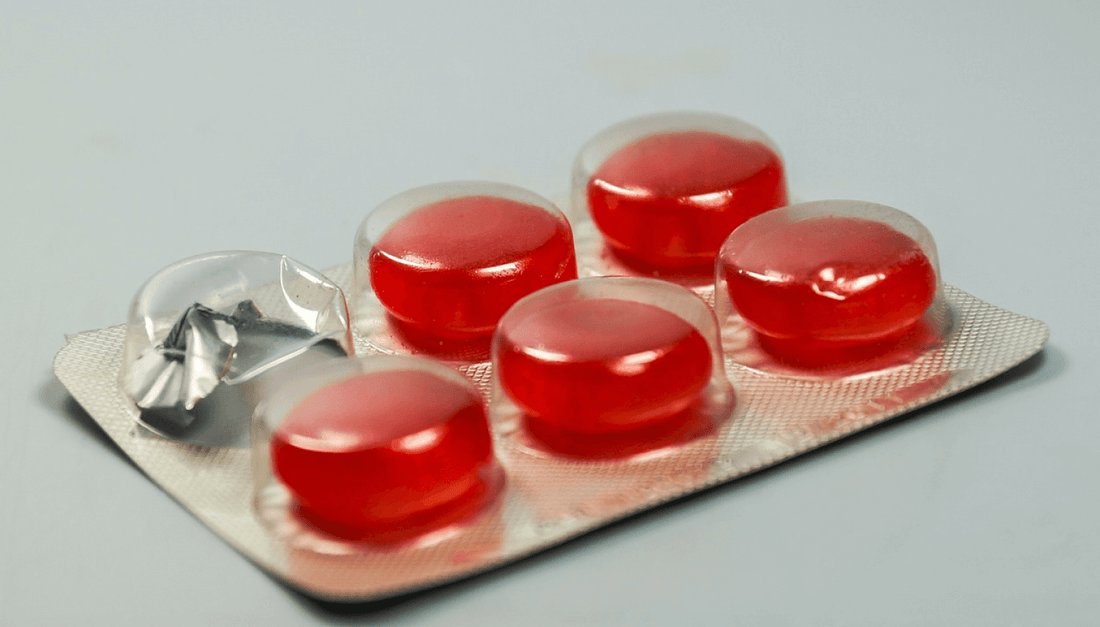 A pack of red jelly pills displayed on a table, emphasizing their bright color and soft, gelatinous appearance